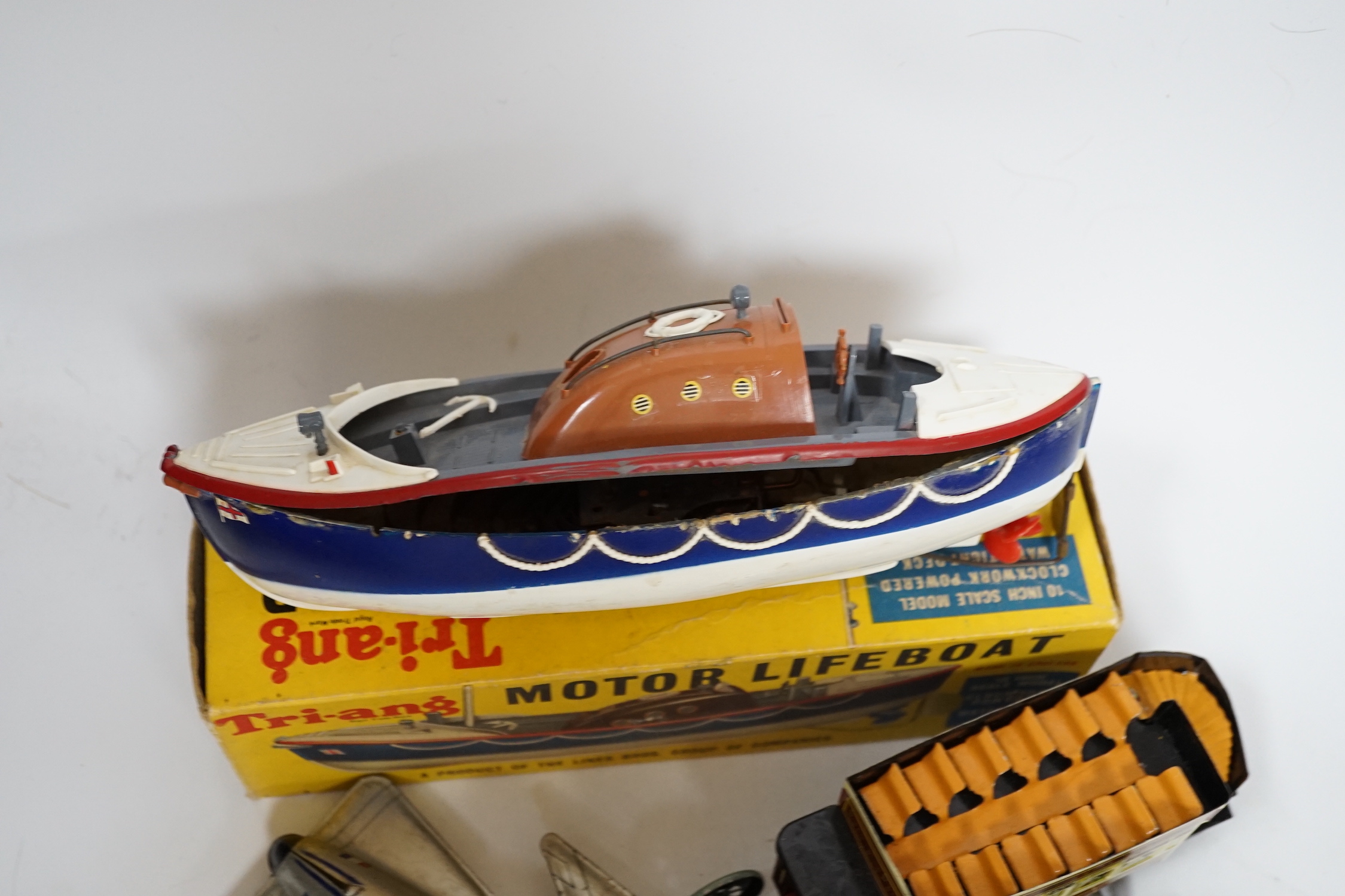 A collection of tinplate toys including cars, a fire engine, a Firebird jet plane, a Tri-ang lifeboat, an Tri-ang Minic tractor, etc. (11), together with a box of boardgames including Vintage Gibson and others; Bandit Ch